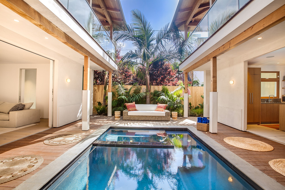 Imagen de piscinas y jacuzzis alargados tropicales rectangulares en patio con entablado