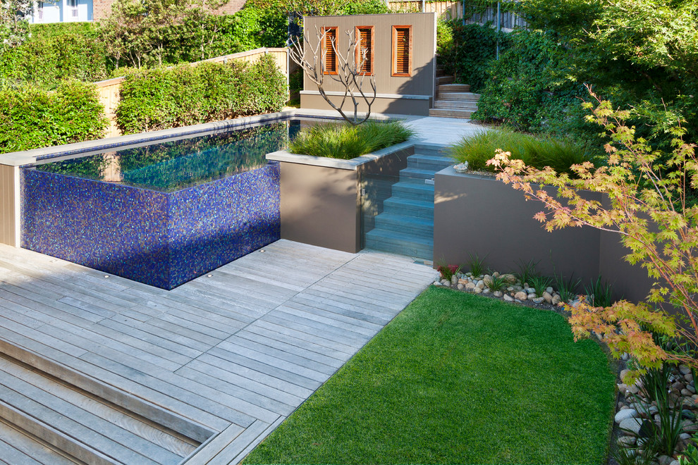 Cette photo montre une petite piscine hors-sol et arrière tendance sur mesure avec une terrasse en bois.