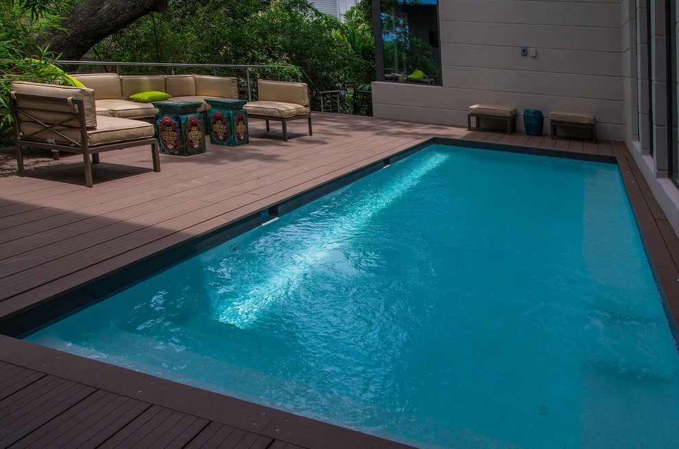 Modelo de piscina moderna pequeña rectangular en patio lateral con entablado