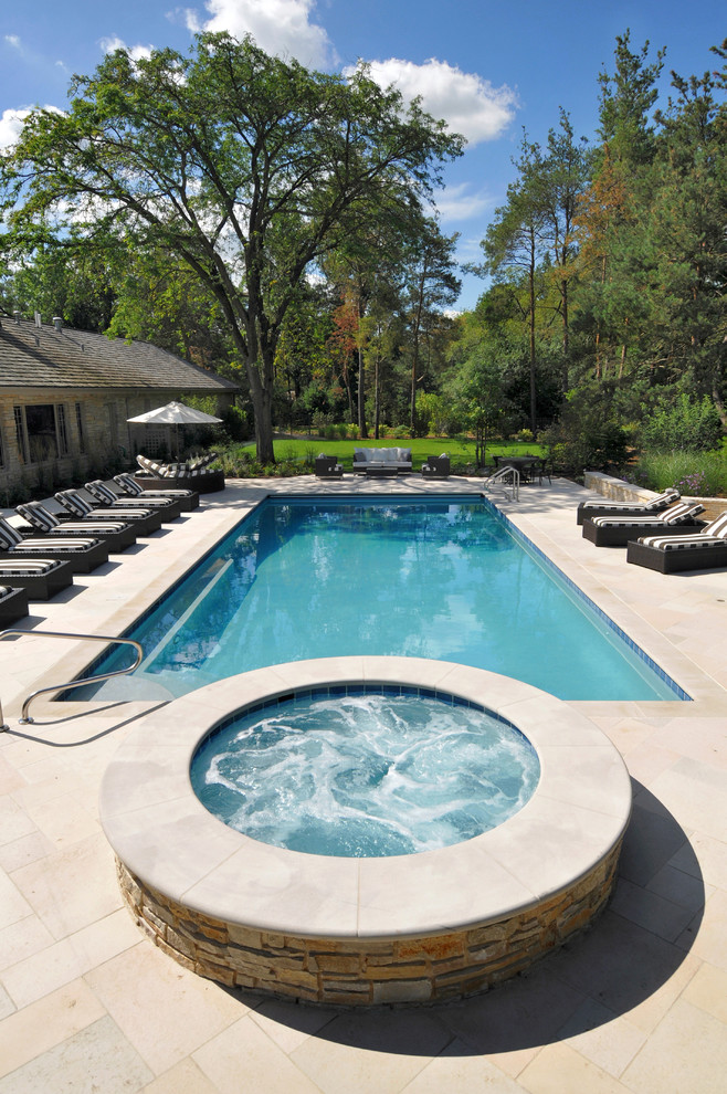 Ejemplo de piscinas y jacuzzis alargados tradicionales de tamaño medio rectangulares en patio trasero con adoquines de piedra natural