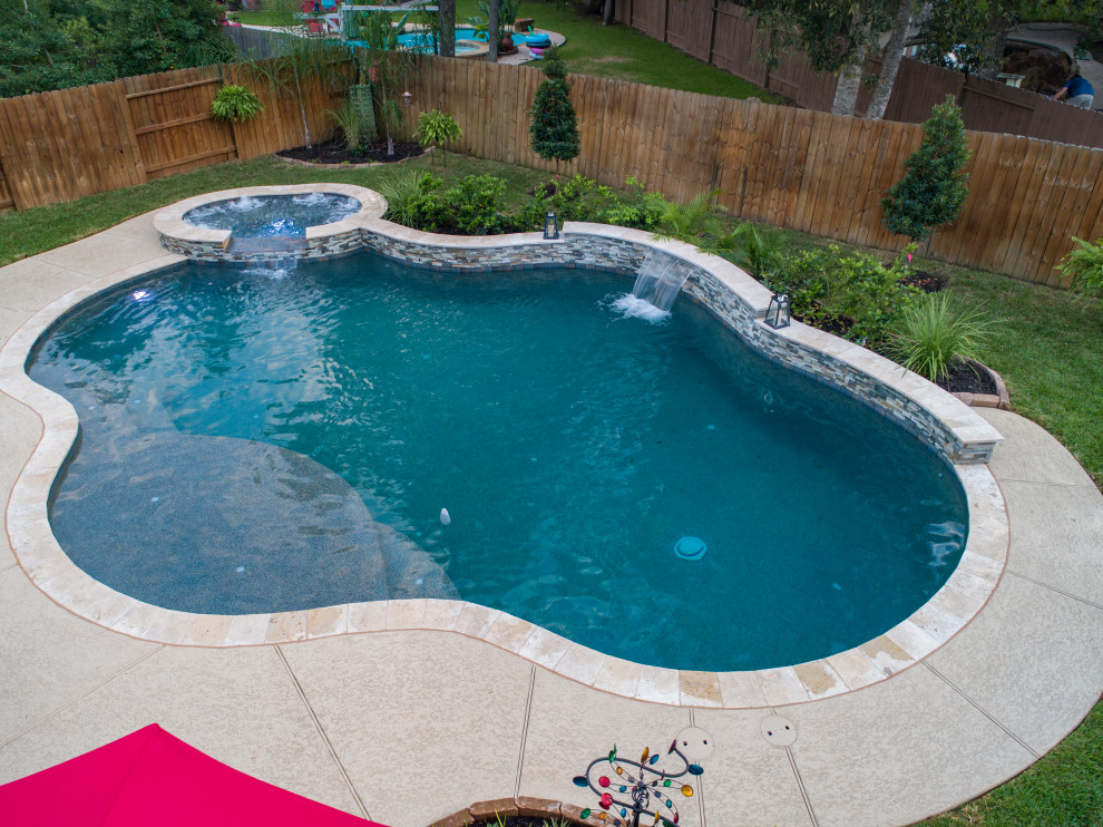 Réalisation d'une piscine arrière design de taille moyenne et sur mesure avec une terrasse en bois.
