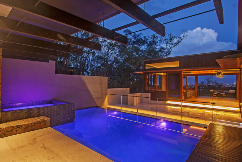 Cette image montre une piscine à débordement design de taille moyenne et rectangle avec un bain bouillonnant, une cour et du carrelage.