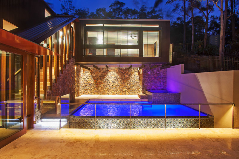 Esempio di una piscina a sfioro infinito contemporanea rettangolare di medie dimensioni e in cortile con una vasca idromassaggio e piastrelle