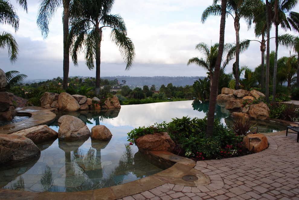 Immagine di una piscina a sfioro infinito tropicale dietro casa