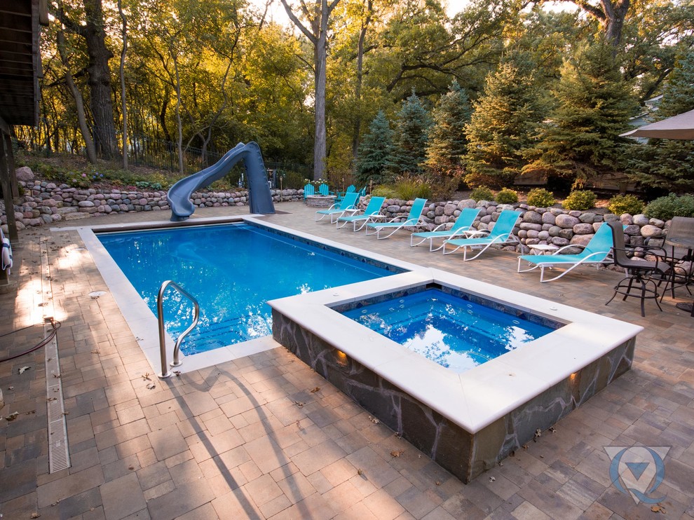 Diseño de piscina alargada clásica de tamaño medio rectangular en patio trasero con adoquines de hormigón