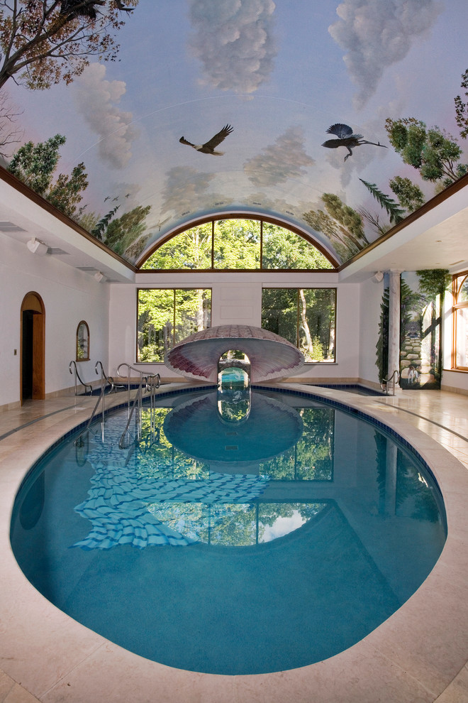 Aménagement d'une très grande piscine intérieure méditerranéenne sur mesure avec des pavés en pierre naturelle et un bain bouillonnant.