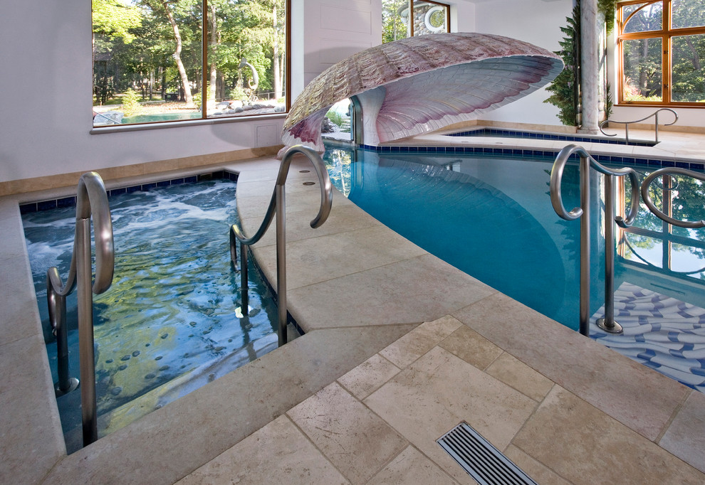 Пример оригинального дизайна: огромный бассейн произвольной формы в доме в средиземноморском стиле с покрытием из каменной брусчатки и джакузи