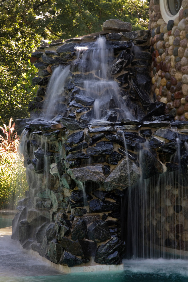 Huge tuscan backyard stone and custom-shaped infinity hot tub photo in Chicago