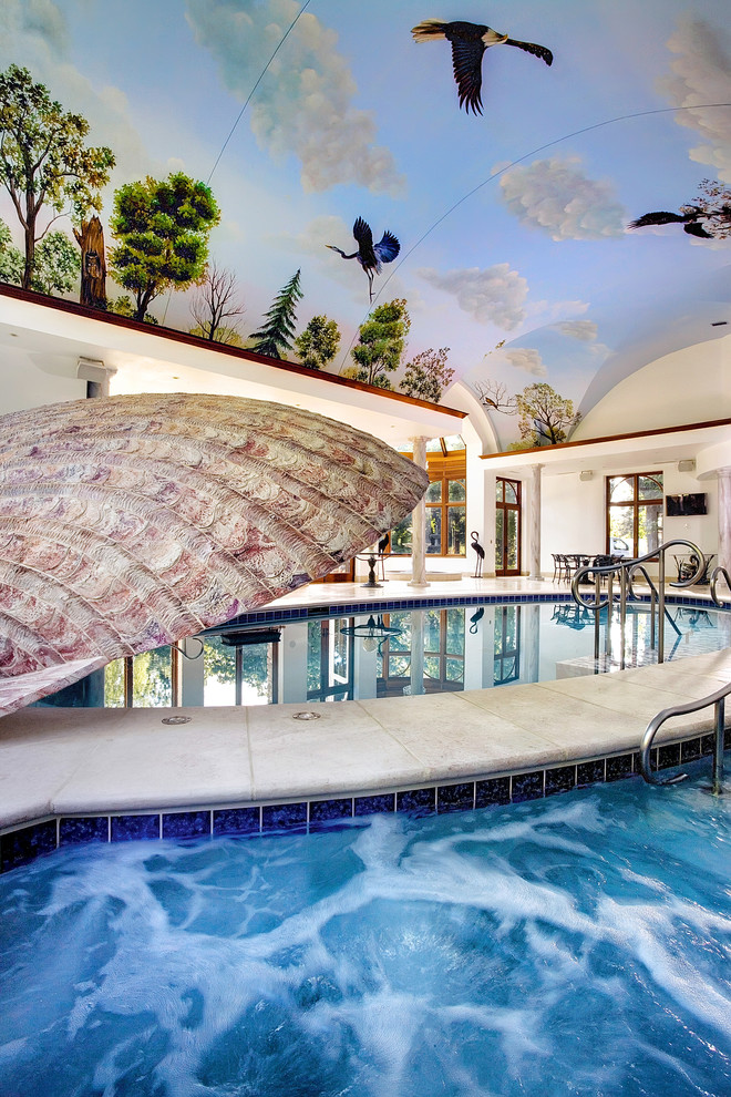 Exemple d'une très grande piscine intérieure méditerranéenne sur mesure avec des pavés en pierre naturelle et un bain bouillonnant.