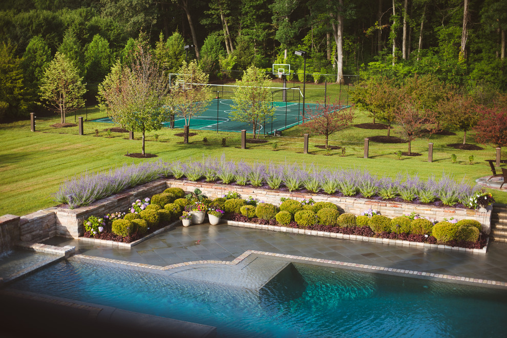 Foto de casa de la piscina y piscina infinita tradicional grande a medida en patio trasero con adoquines de piedra natural