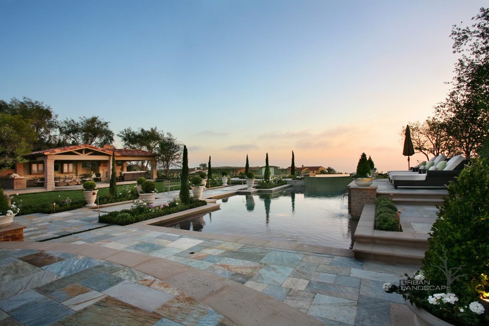 Large elegant backyard stone and rectangular natural pool fountain photo in Orange County