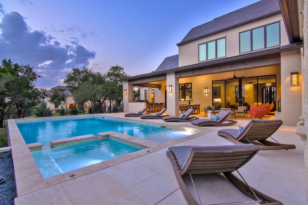 Foto di una grande piscina monocorsia minimal rettangolare dietro casa con una vasca idromassaggio e piastrelle