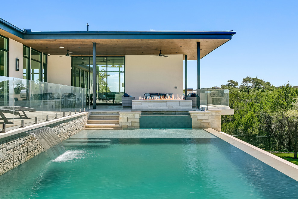 Großer Moderner Infinity-Pool hinter dem Haus in rechteckiger Form mit Wasserspiel in Austin