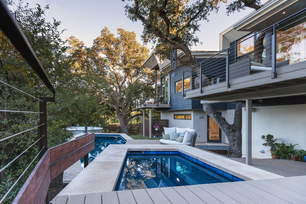 Aménagement d'une grande piscine contemporaine sur mesure avec une terrasse en bois.