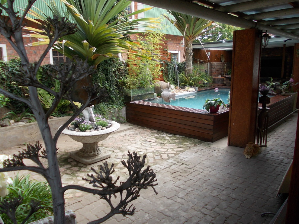Imagen de piscina con fuente elevada rural de tamaño medio rectangular en patio con entablado