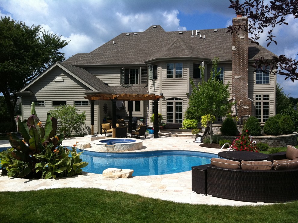 Diseño de piscinas y jacuzzis clásicos de tamaño medio a medida en patio trasero con adoquines de piedra natural