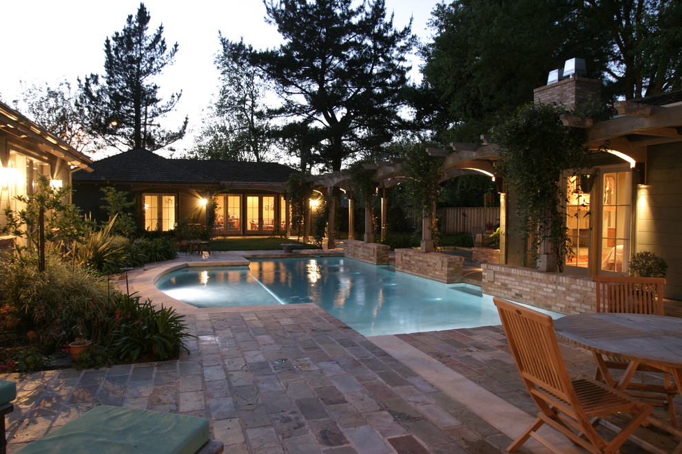 Immagine di una grande piscina tradizionale dietro casa con piastrelle