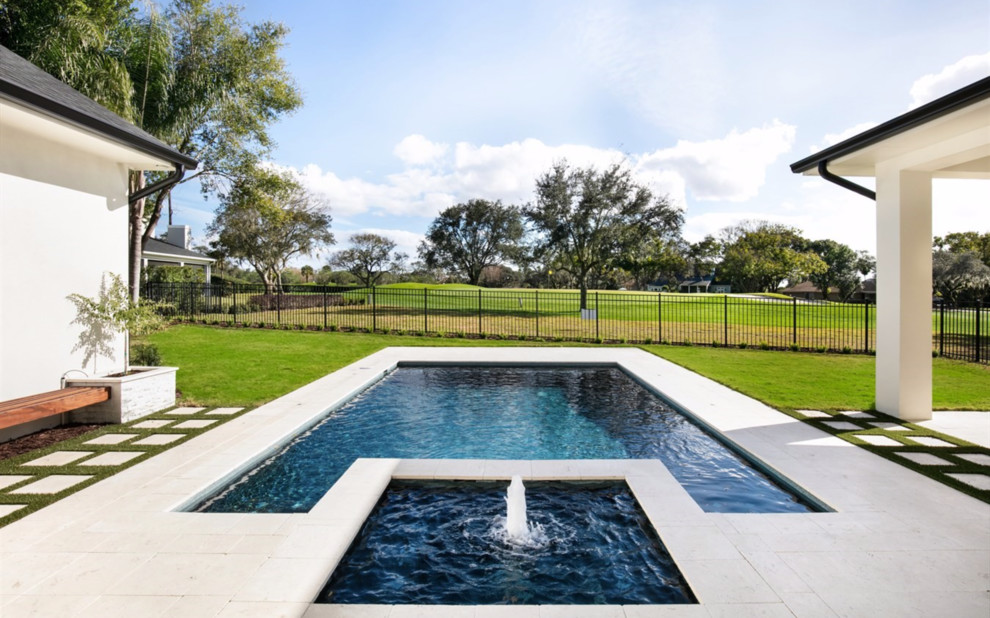 Inspiration for a large transitional backyard stone and rectangular hot tub remodel in Orlando