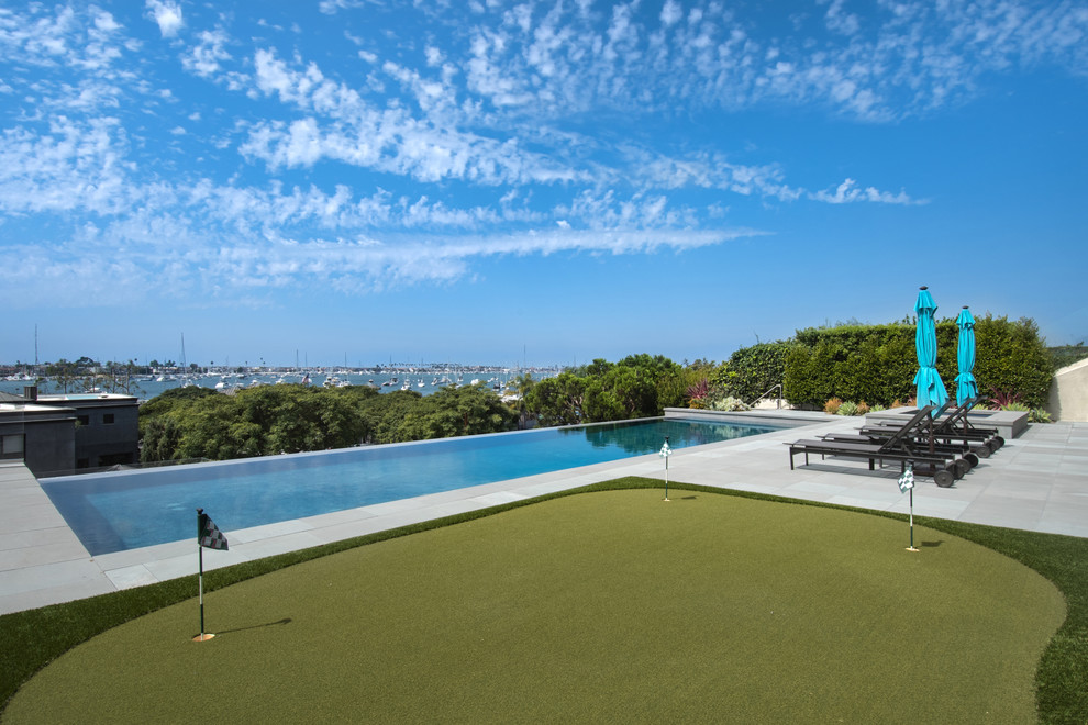 Modelo de piscinas y jacuzzis infinitos actuales grandes rectangulares en patio trasero con suelo de hormigón estampado