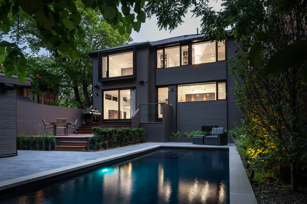 Mittelgroßer Moderner Pool hinter dem Haus in rechteckiger Form mit Betonplatten in Toronto