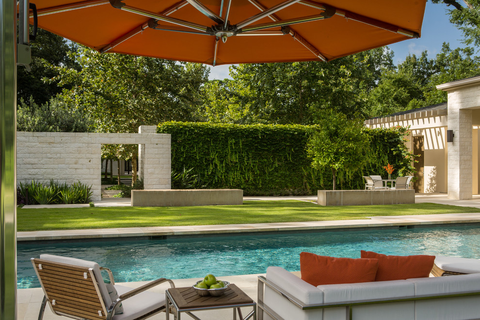 Diseño de piscina clásica renovada grande rectangular en patio trasero con adoquines de piedra natural