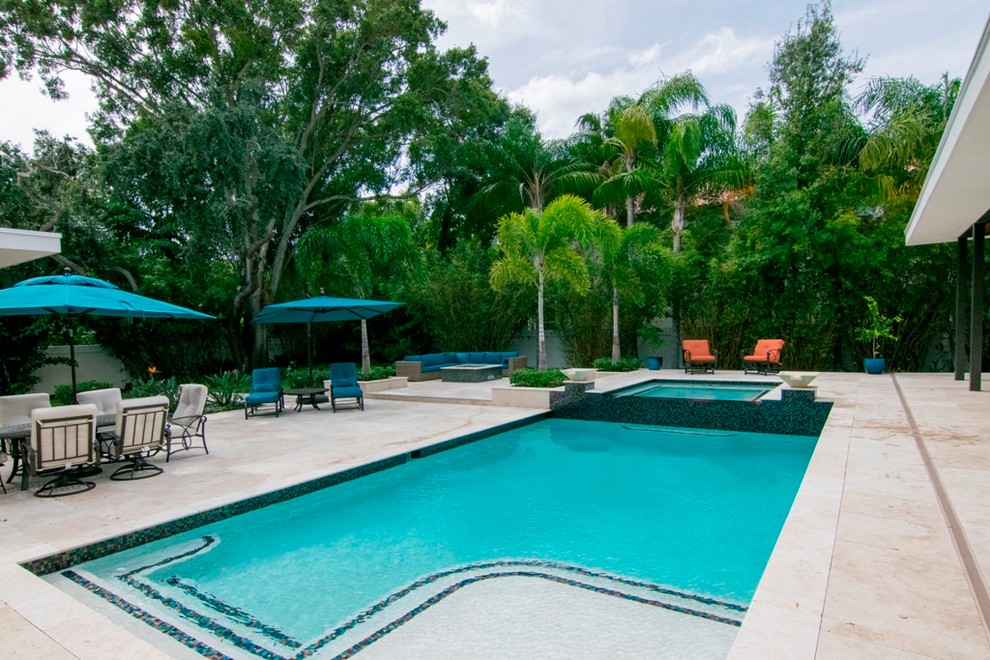 Esempio di una piscina design rettangolare di medie dimensioni e dietro casa con piastrelle