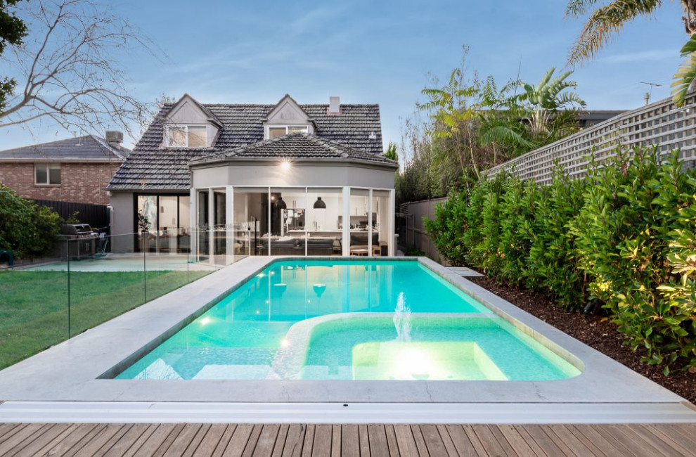 Example of a mid-sized trendy backyard concrete and custom-shaped pool landscaping design in Melbourne