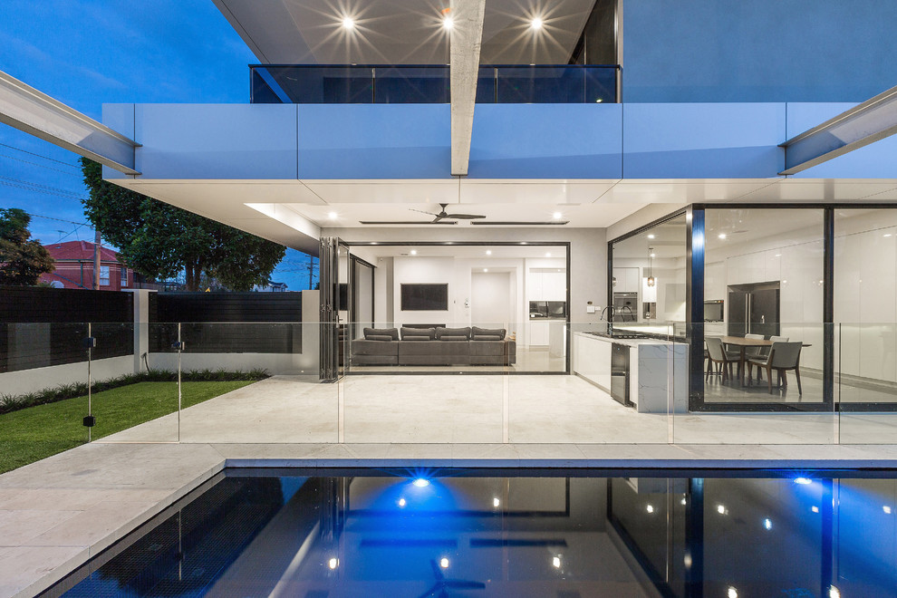 Foto de piscina con fuente minimalista de tamaño medio rectangular en patio lateral con adoquines de hormigón