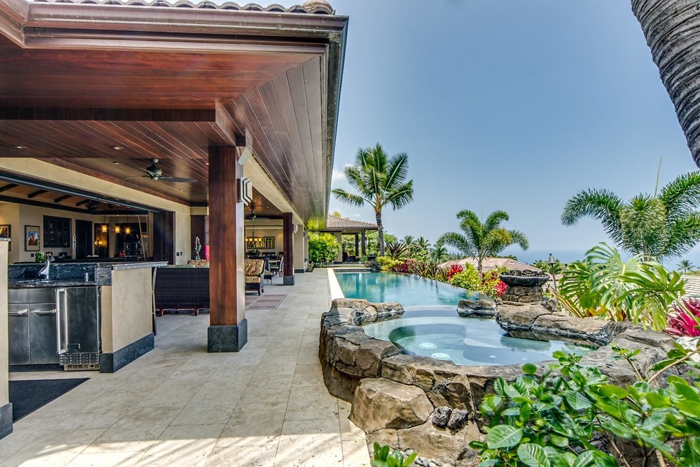 Diseño de piscina tropical extra grande en patio lateral con suelo de baldosas