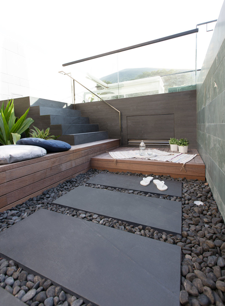 Ejemplo de casa de la piscina y piscina infinita moderna de tamaño medio rectangular en azotea con adoquines de piedra natural