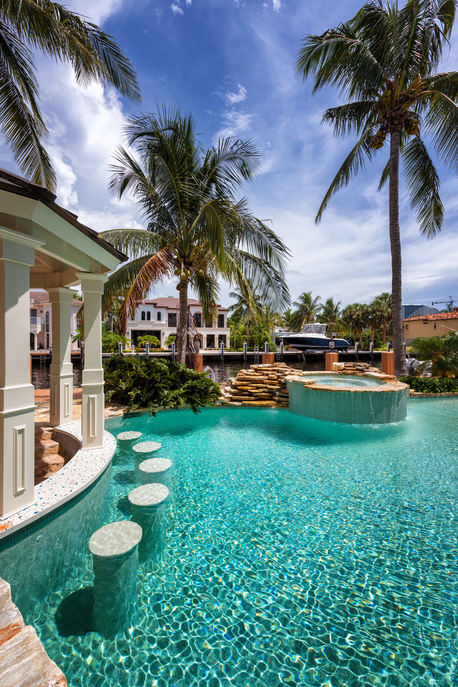 Foto di una piscina naturale stile marinaro personalizzata di medie dimensioni e dietro casa con una vasca idromassaggio e pavimentazioni in pietra naturale