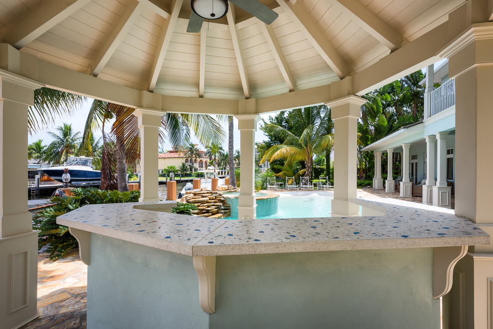 This is an example of a medium sized coastal back custom shaped natural hot tub in Miami with natural stone paving.