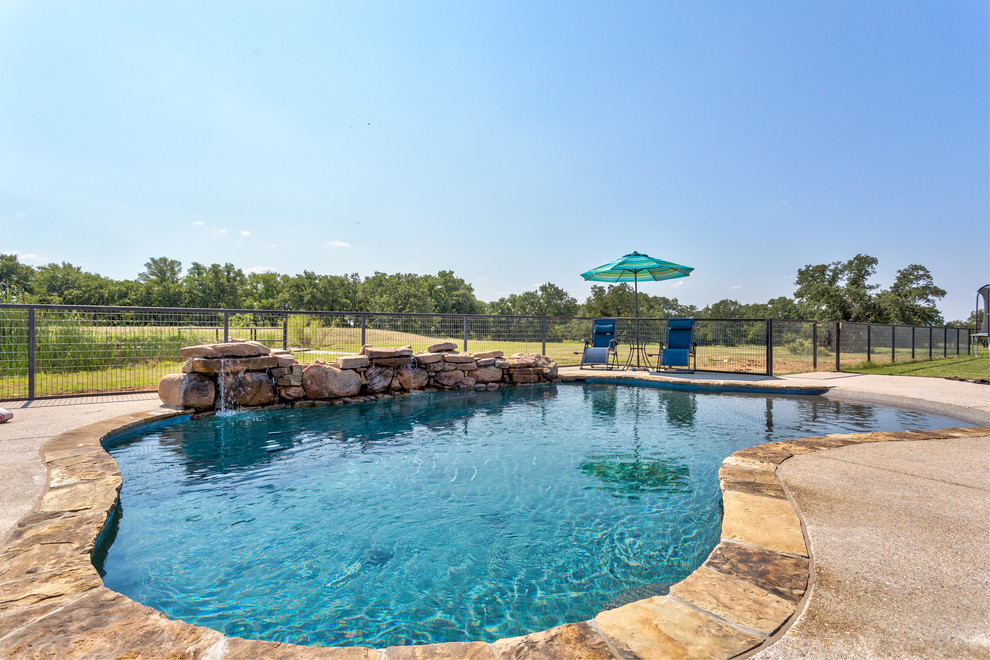Design ideas for a medium sized traditional back custom shaped swimming pool in Dallas with concrete slabs.