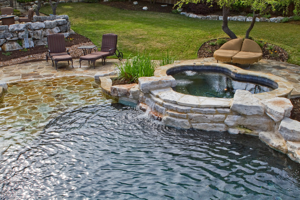 На фото: естественный бассейн среднего размера, произвольной формы на заднем дворе в классическом стиле с покрытием из каменной брусчатки и джакузи с