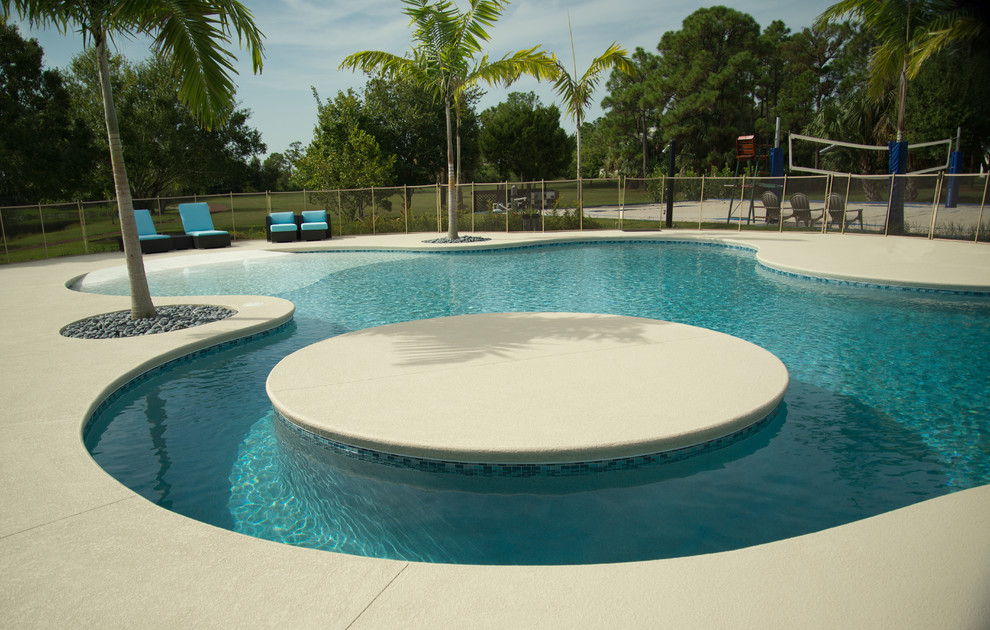 Esempio di un'ampia piscina naturale stile marino personalizzata dietro casa con pedane