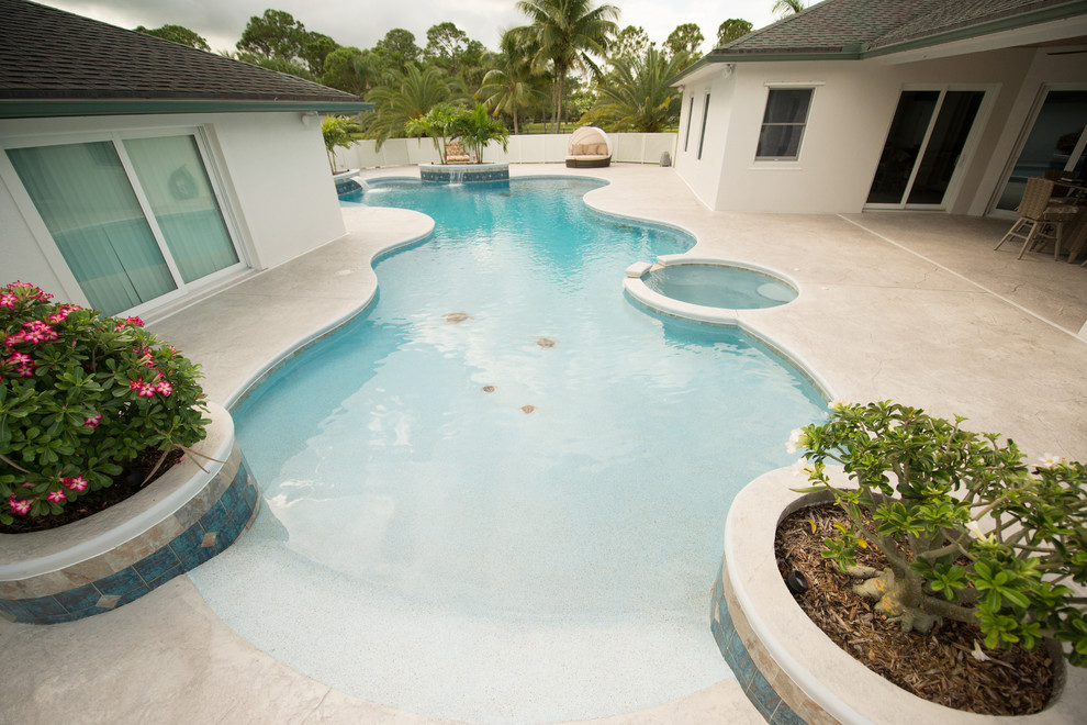 Exemple d'une grande piscine naturelle bord de mer sur mesure avec une cour et du béton estampé.