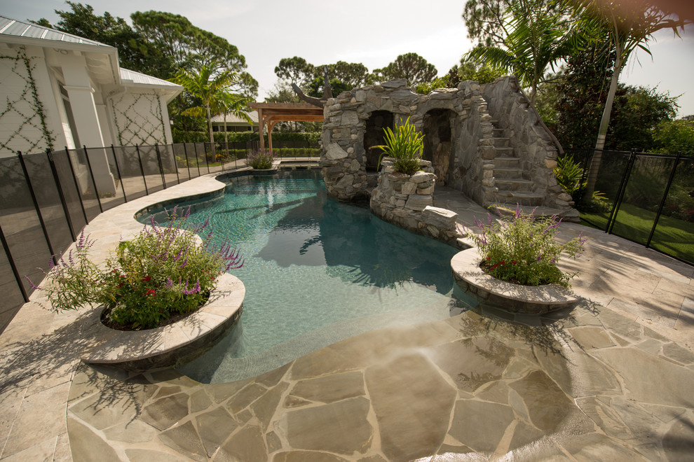 Idee per una grande piscina naturale stile marino personalizzata dietro casa con pavimentazioni in pietra naturale