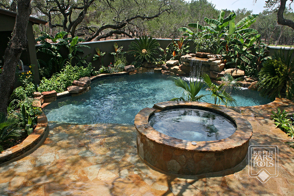 Modelo de piscinas y jacuzzis naturales marineros de tamaño medio a medida en patio trasero con adoquines de piedra natural