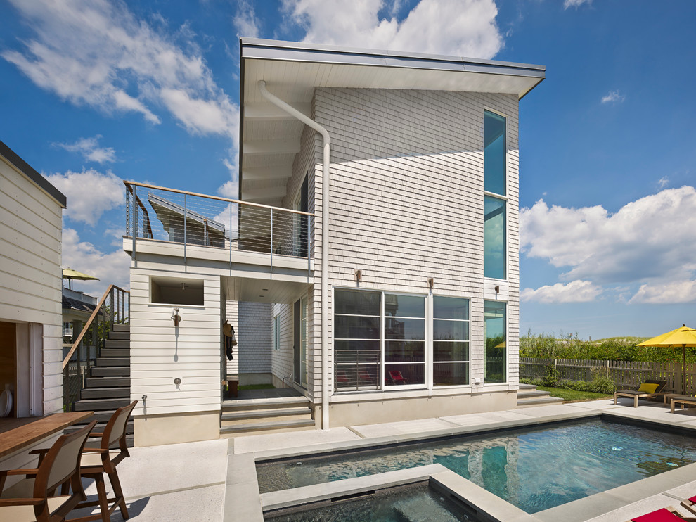 Ispirazione per una piccola piscina stile marino rettangolare nel cortile laterale con una vasca idromassaggio e pavimentazioni in cemento