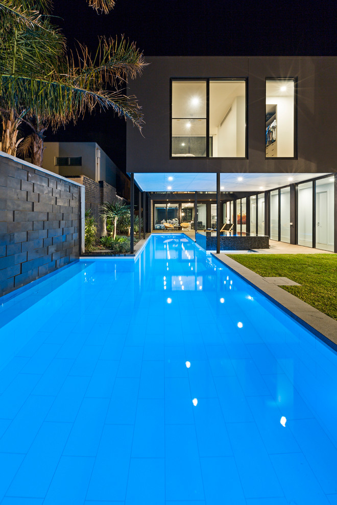 This is an example of a large contemporary back l-shaped lengths hot tub in Melbourne with concrete paving.