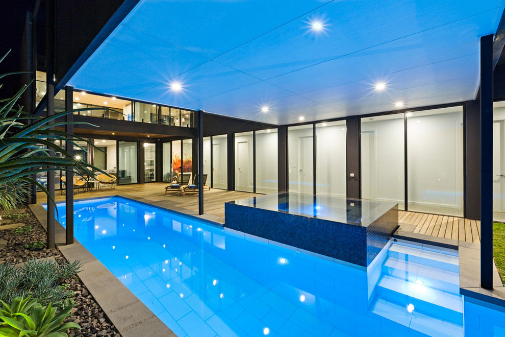 Großer Moderner Pool hinter dem Haus in L-Form mit Betonboden in Melbourne