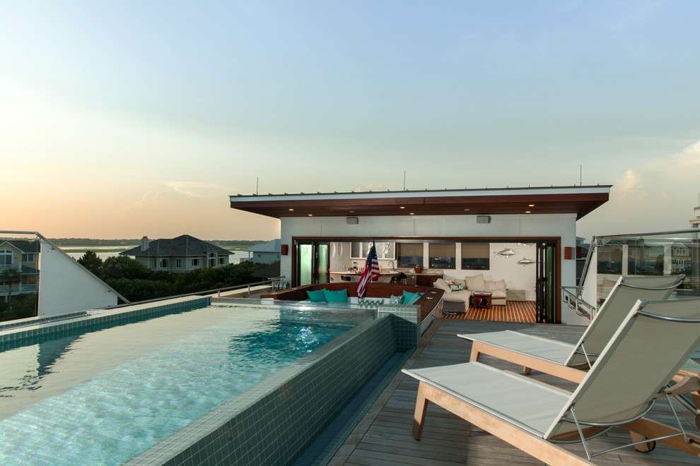 Idées déco pour une petite piscine sur toit à débordement moderne rectangle avec un point d'eau et une terrasse en bois.