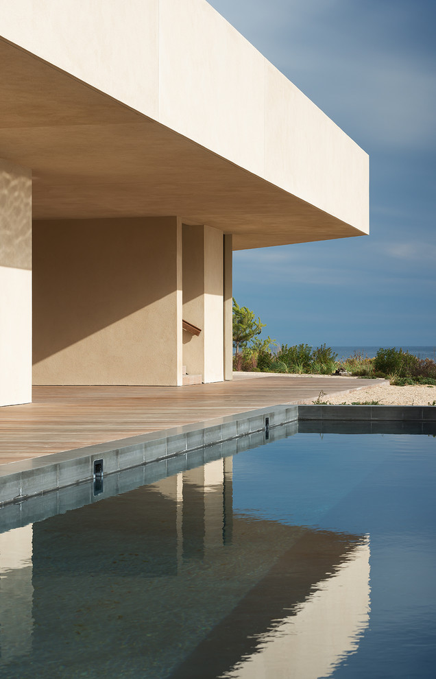 Imagen de piscina alargada moderna rectangular en patio lateral con entablado