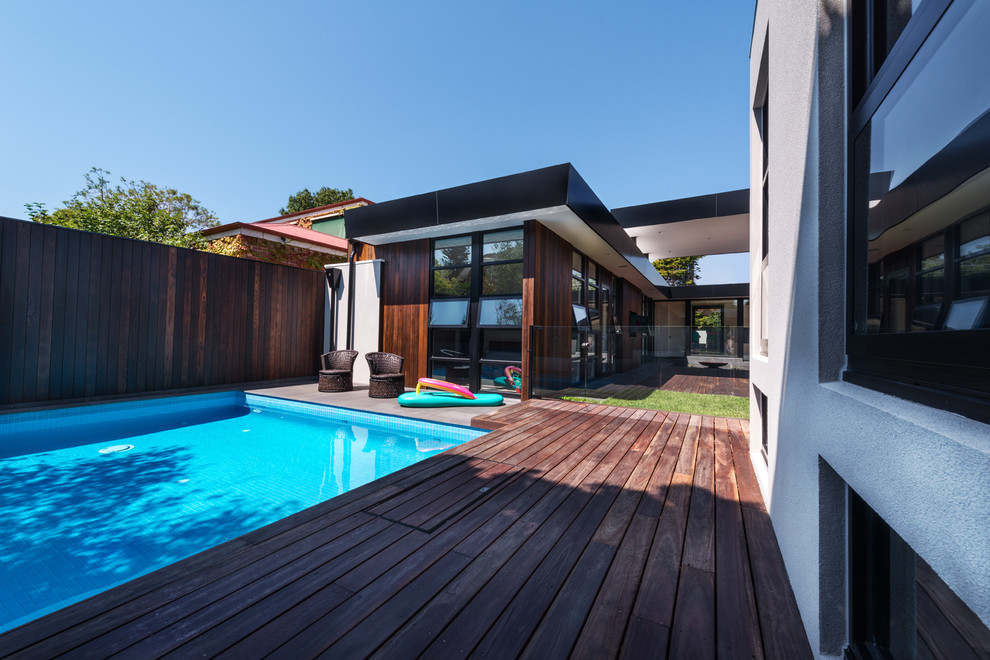 Imagen de piscina alargada retro de tamaño medio rectangular en patio trasero con adoquines de piedra natural