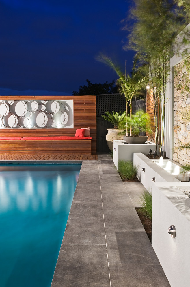 Ejemplo de piscina con fuente contemporánea grande rectangular en patio trasero con entablado