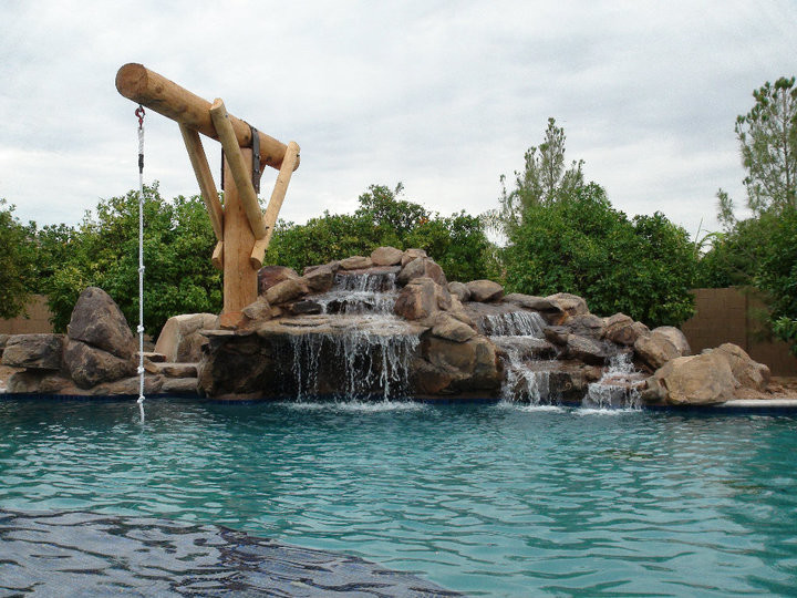 Pool fountain - large rustic backyard custom-shaped pool fountain idea in Phoenix