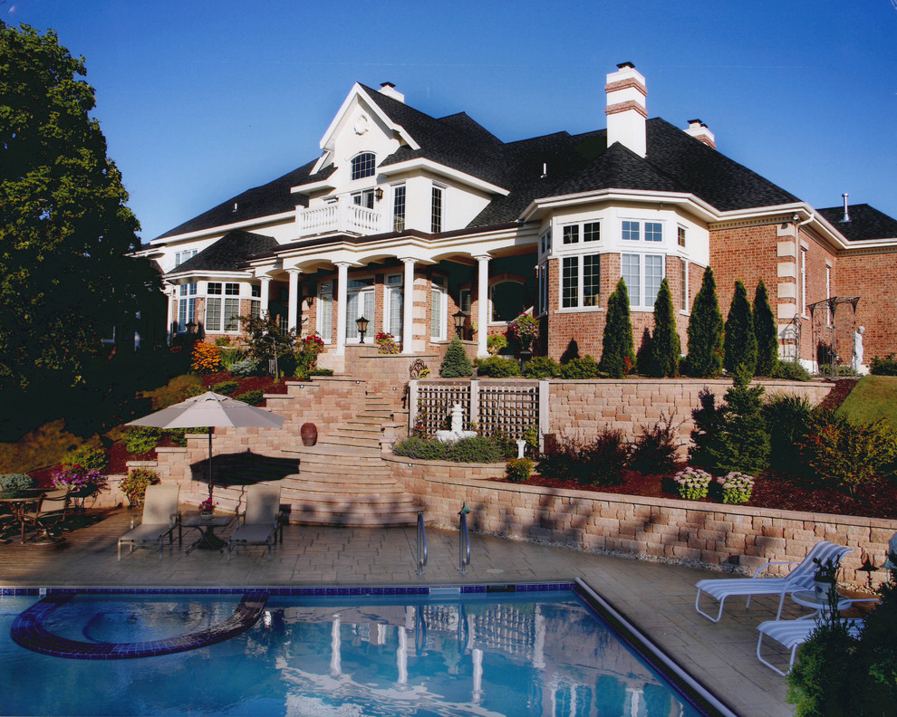 Пример оригинального дизайна: большой естественный, прямоугольный бассейн на заднем дворе в классическом стиле с джакузи и мощением клинкерной брусчаткой