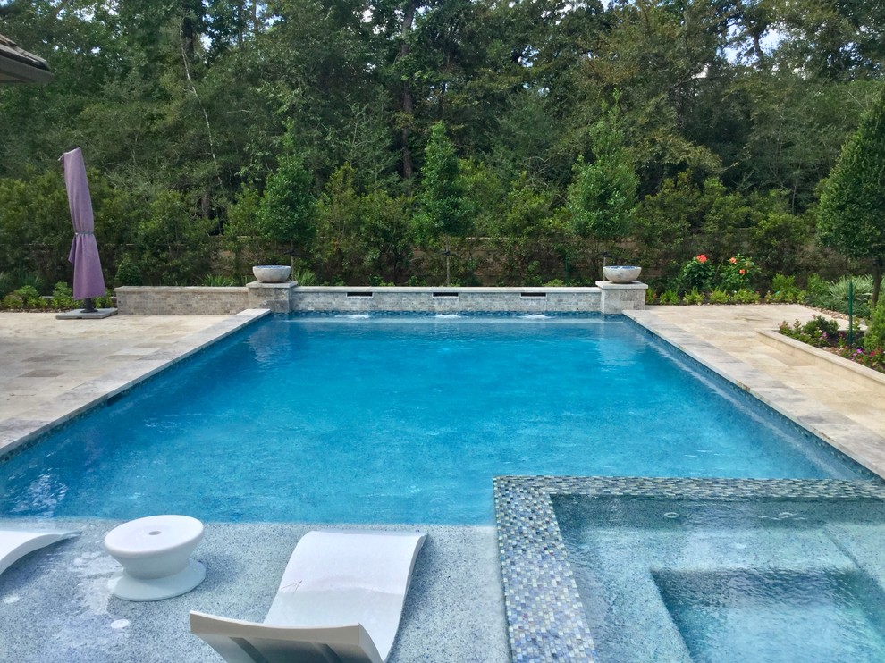 Foto de piscina con fuente alargada clásica renovada grande rectangular en patio trasero con adoquines de piedra natural
