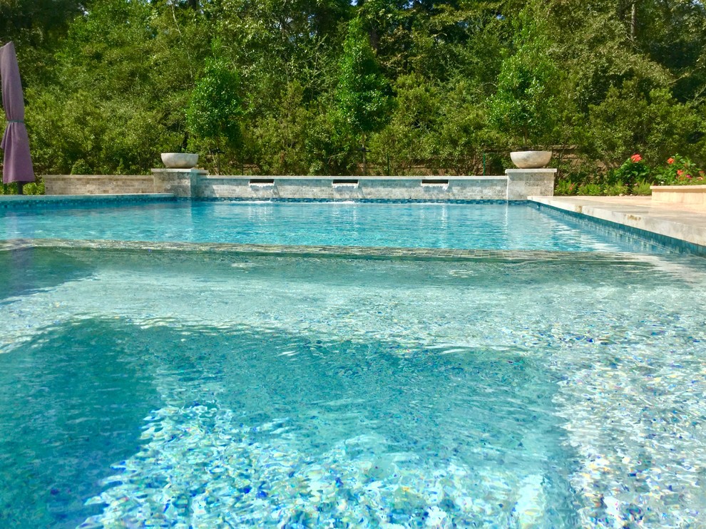 Example of a large transitional backyard stone and rectangular lap pool fountain design in Houston
