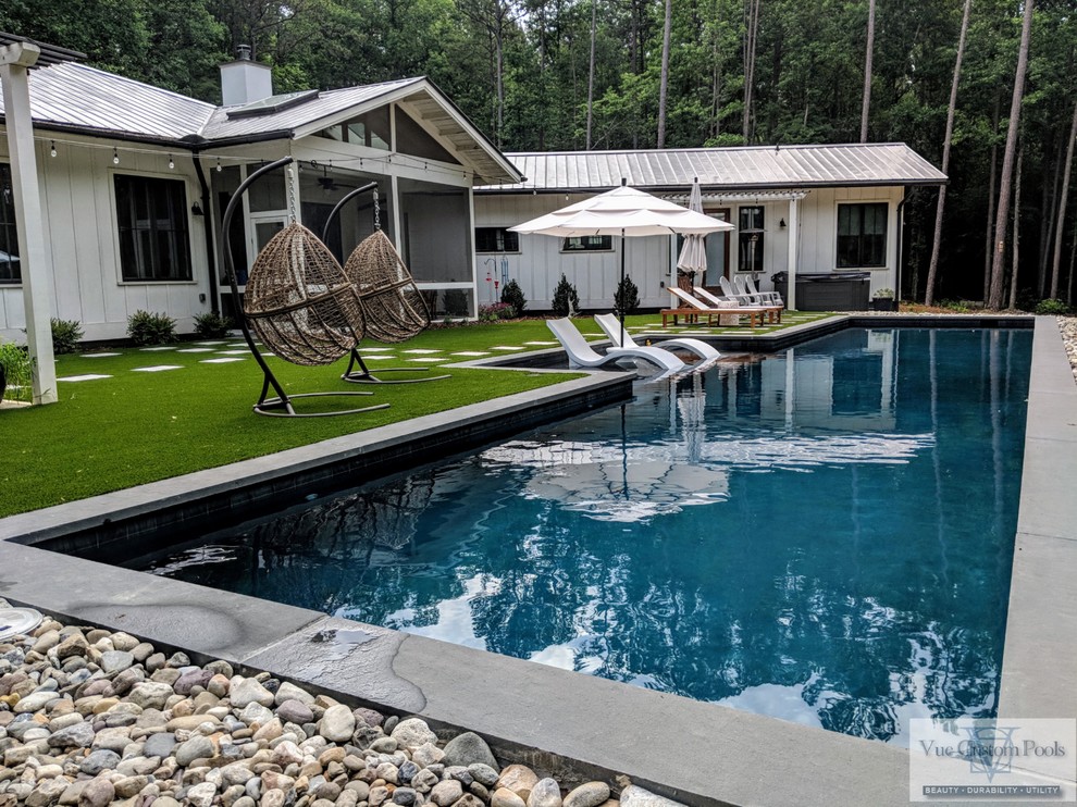 Diseño de piscina alargada contemporánea grande a medida en patio trasero con suelo de baldosas